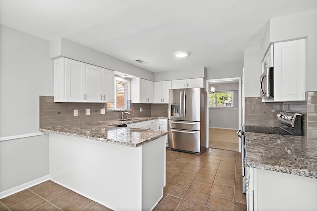 kitchen with white cabinetry, appliances with stainless steel finishes, and tasteful backsplash