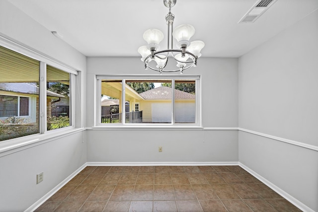 unfurnished dining area with tile patterned floors and a notable chandelier