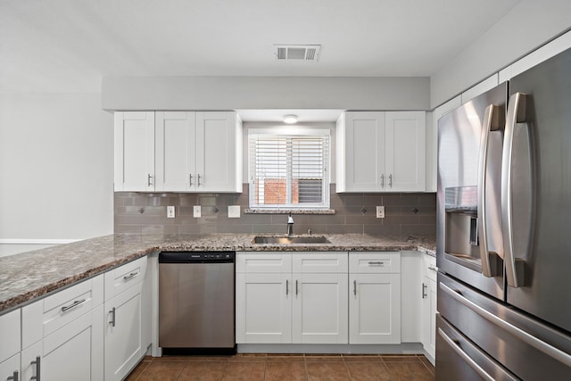 kitchen with sink, backsplash, white cabinets, and stainless steel appliances