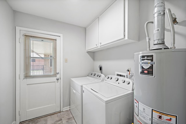 laundry room with washing machine and clothes dryer, cabinets, and water heater