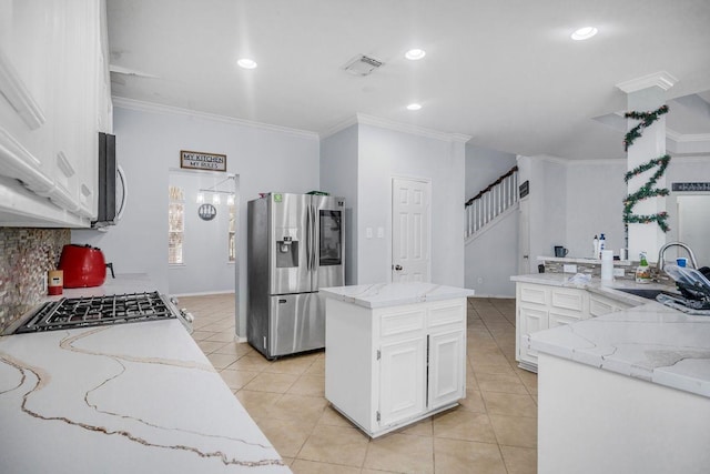 kitchen featuring stainless steel refrigerator with ice dispenser, sink, white cabinetry, a center island, and ornamental molding