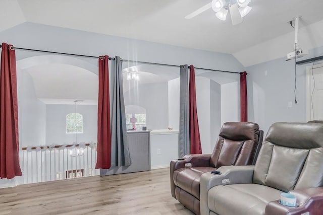 home theater room featuring ceiling fan, radiator, vaulted ceiling, and light wood-type flooring