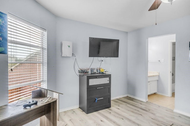 interior space featuring ceiling fan, connected bathroom, and light hardwood / wood-style flooring