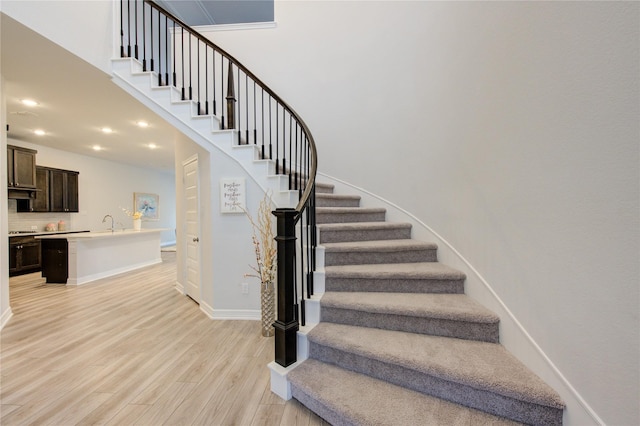 stairs with sink and hardwood / wood-style floors