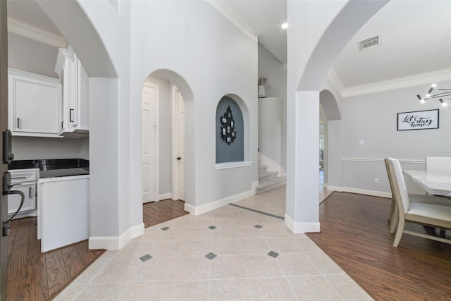 foyer with light tile patterned floors and ornamental molding