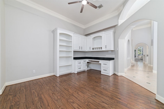 unfurnished office featuring ceiling fan, dark hardwood / wood-style flooring, and ornamental molding