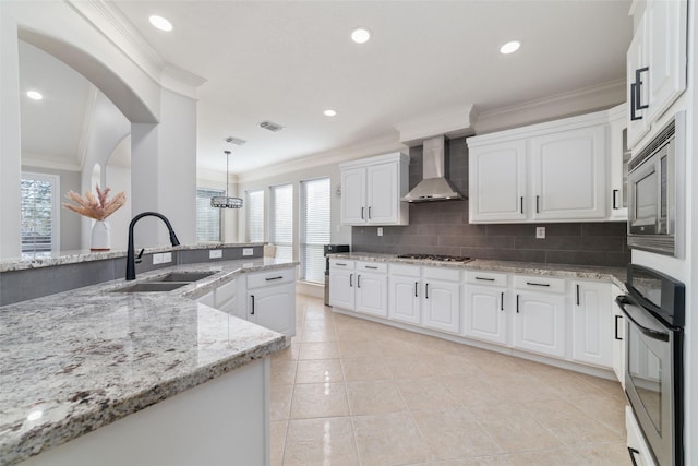 kitchen with sink, white cabinets, wall chimney exhaust hood, and stainless steel appliances