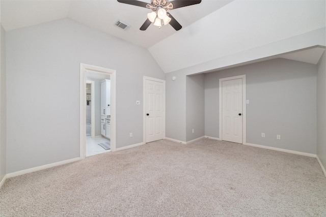 interior space with ensuite bath, a closet, vaulted ceiling, ceiling fan, and light colored carpet