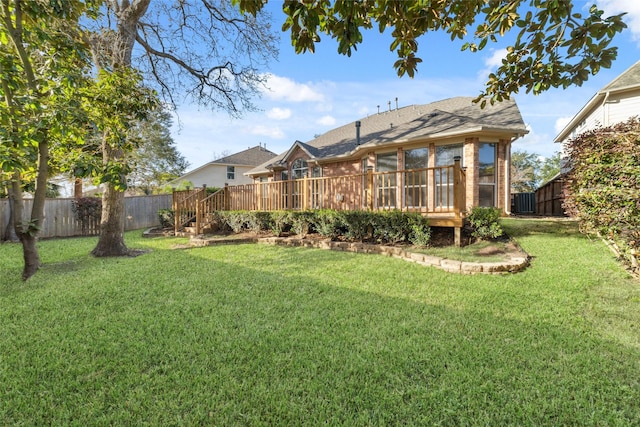 rear view of house with a lawn and a wooden deck