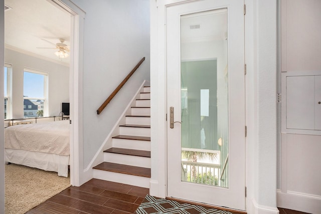 staircase with a ceiling fan, a wealth of natural light, crown molding, and wood tiled floor