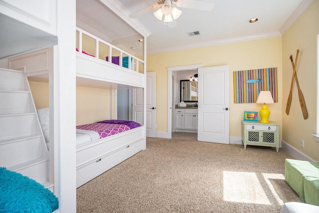 carpeted bedroom featuring ornamental molding, ceiling fan, and ensuite bath