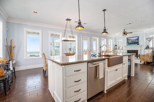 kitchen with sink, decorative light fixtures, stainless steel dishwasher, a kitchen island with sink, and white cabinets