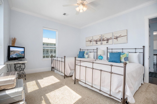 carpeted bedroom with baseboards, visible vents, crown molding, and a ceiling fan