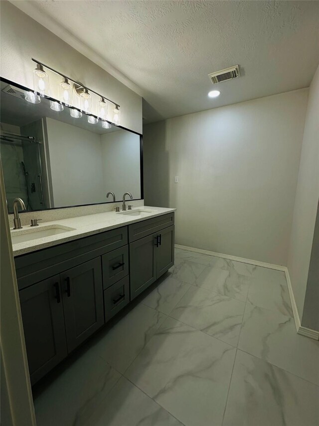 bathroom with a shower with door, a textured ceiling, and vanity