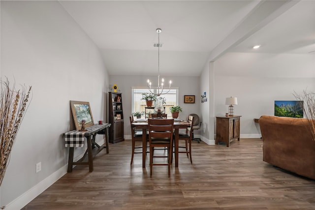 dining space featuring dark hardwood / wood-style floors, lofted ceiling, and a chandelier