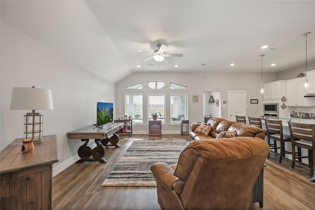 living room featuring ceiling fan, vaulted ceiling, and dark wood-type flooring