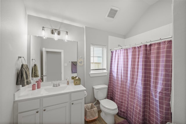 bathroom with toilet, vanity, a shower with curtain, and vaulted ceiling