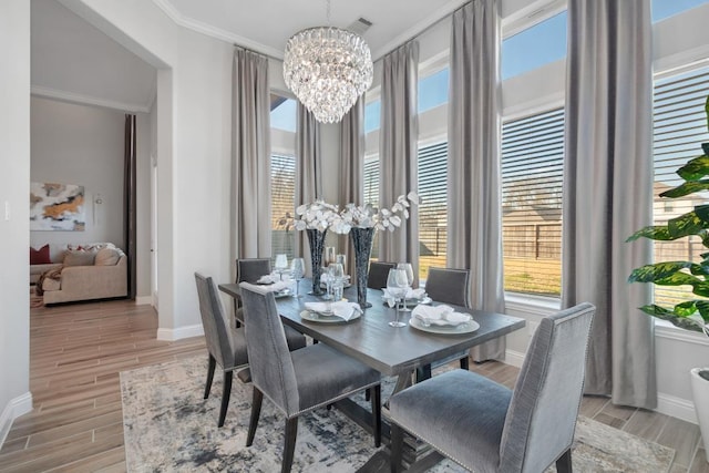 dining space with crown molding, a wealth of natural light, and an inviting chandelier