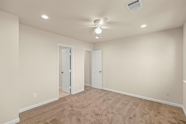 spare room featuring ceiling fan and light colored carpet