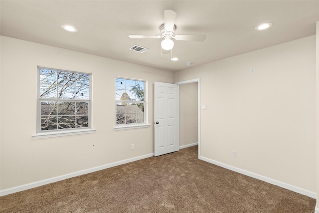 carpeted spare room with ceiling fan