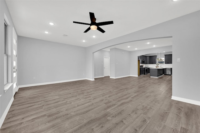 unfurnished living room featuring hardwood / wood-style flooring and ceiling fan