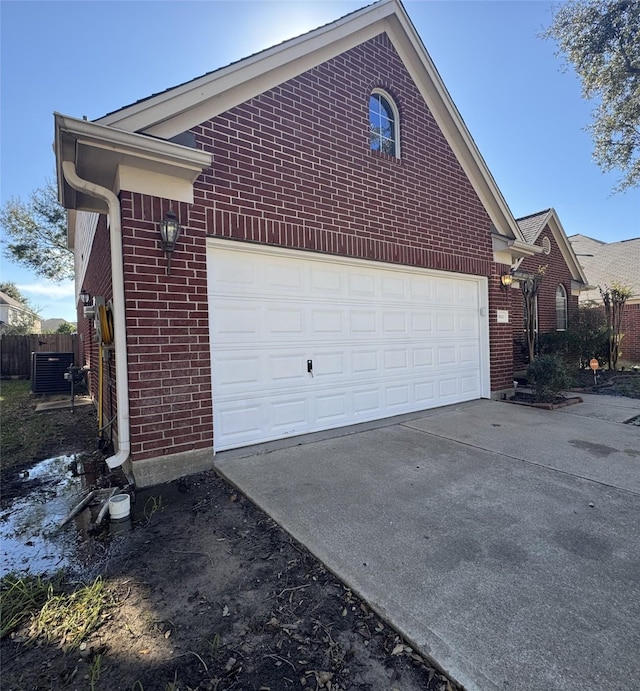 view of side of home featuring a garage and cooling unit