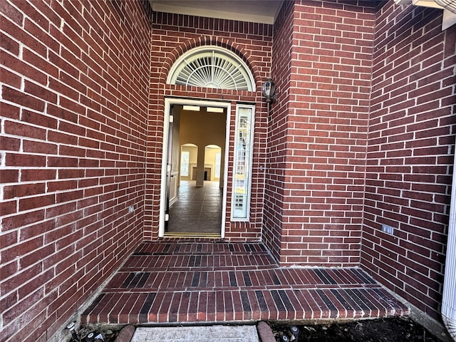 entrance to property featuring brick siding