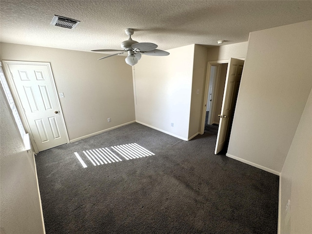 unfurnished room featuring dark colored carpet, a textured ceiling, and ceiling fan