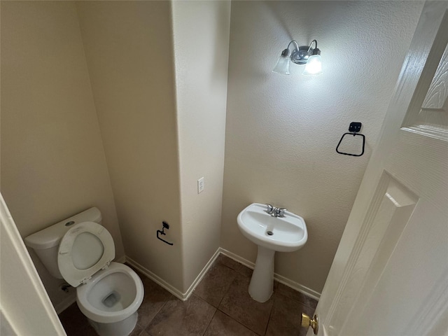 bathroom with toilet and tile patterned flooring