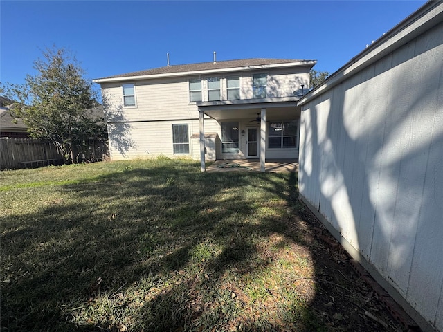 back of house featuring a patio and a yard