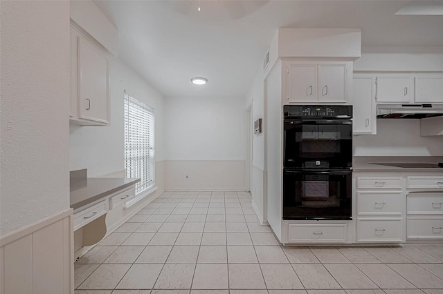 kitchen featuring light tile patterned floors, black appliances, and white cabinets