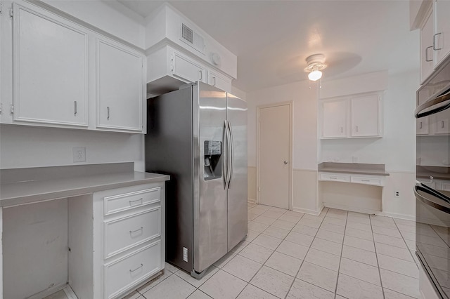 kitchen with stainless steel refrigerator with ice dispenser, white cabinetry, and light tile patterned flooring