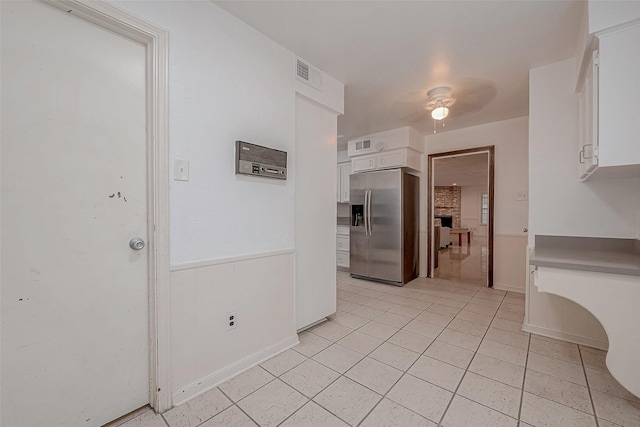 kitchen with white cabinets, stainless steel fridge, and ceiling fan