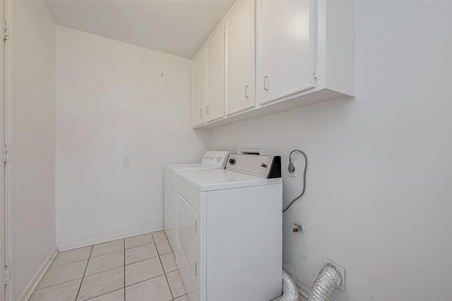 clothes washing area with light tile patterned flooring, cabinets, and washer / clothes dryer