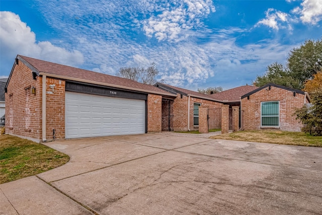 ranch-style home featuring a garage and a front lawn