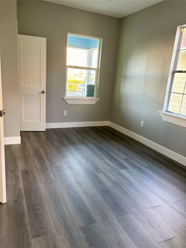 unfurnished room with dark wood-type flooring