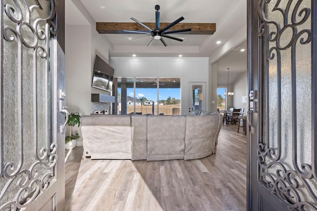 living room featuring ceiling fan, beamed ceiling, and light hardwood / wood-style floors