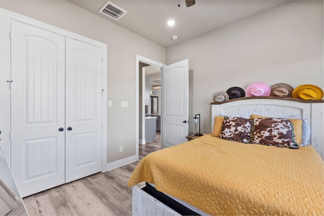 bedroom featuring ceiling fan, a closet, and light wood-type flooring