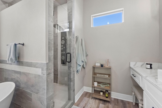 bathroom with independent shower and bath, hardwood / wood-style flooring, and vanity