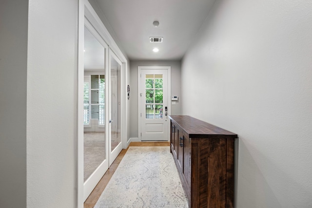 entryway with light wood-style flooring, visible vents, and baseboards