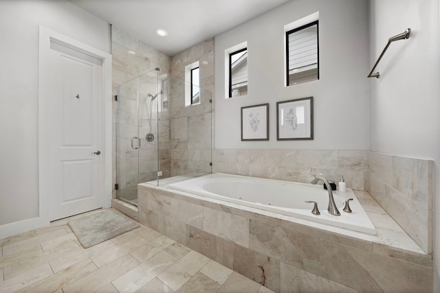 bathroom with a stall shower and a garden tub