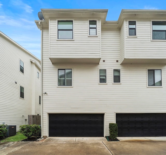 exterior space with central air condition unit and a garage