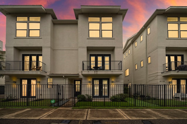 view of front of home featuring a fenced front yard, french doors, and stucco siding