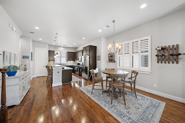 dining area with baseboards, visible vents, dark wood-style flooring, an inviting chandelier, and recessed lighting