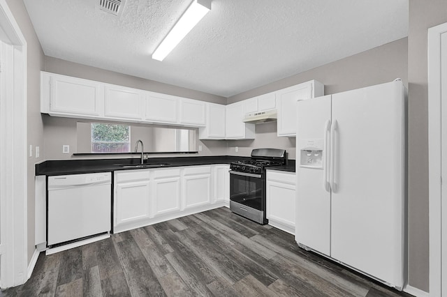 kitchen featuring dark hardwood / wood-style floors, sink, white cabinets, white appliances, and a textured ceiling