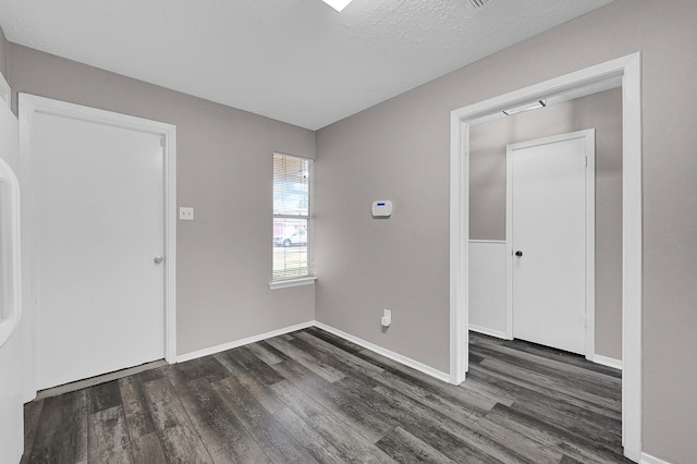 entrance foyer with dark wood-type flooring and a textured ceiling