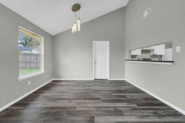 unfurnished dining area with high vaulted ceiling, dark hardwood / wood-style flooring, a chandelier, and sink