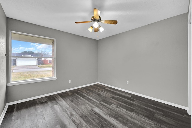 empty room with ceiling fan and dark hardwood / wood-style flooring