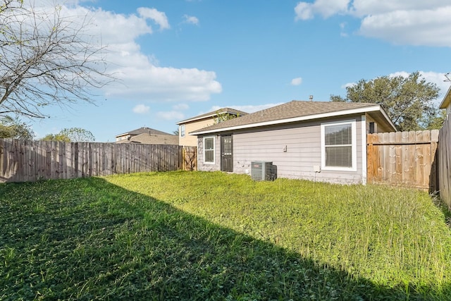 rear view of property featuring a yard and central AC