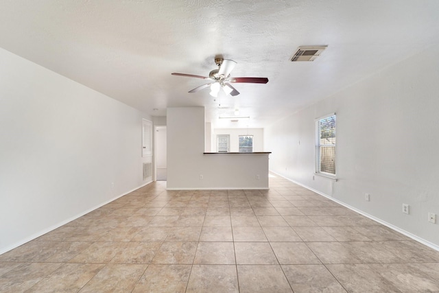 unfurnished living room featuring ceiling fan, a textured ceiling, and light tile patterned flooring